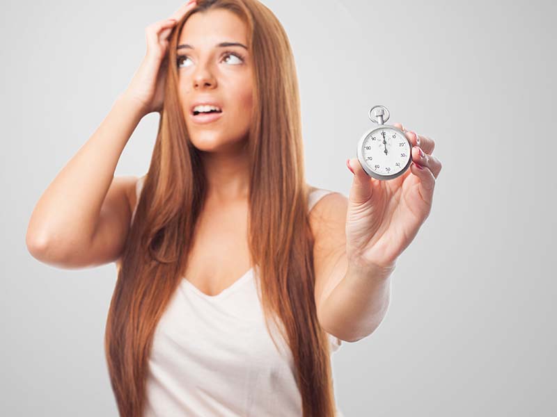 portrait of a beautiful young woman holding a stopwatch